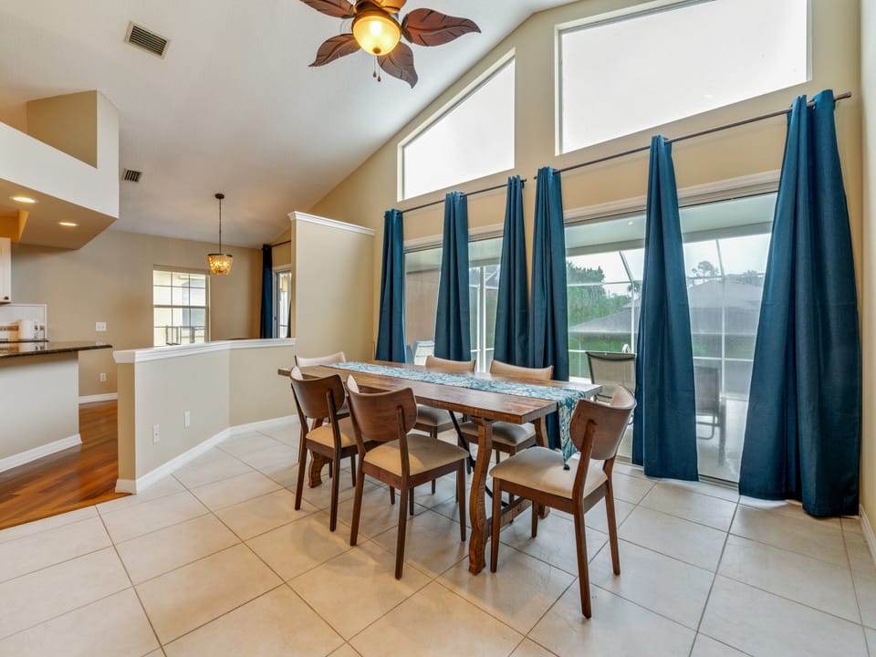 Black out curtains across sliding glass doors.  Dining overlooks pool. (Chairs are now different)