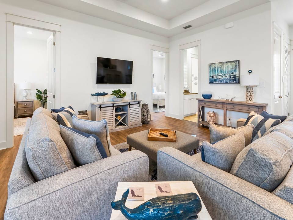 Inviting coastal living room with plush seating, beachy accents, warm wood floors, and relaxed vacation vibes.