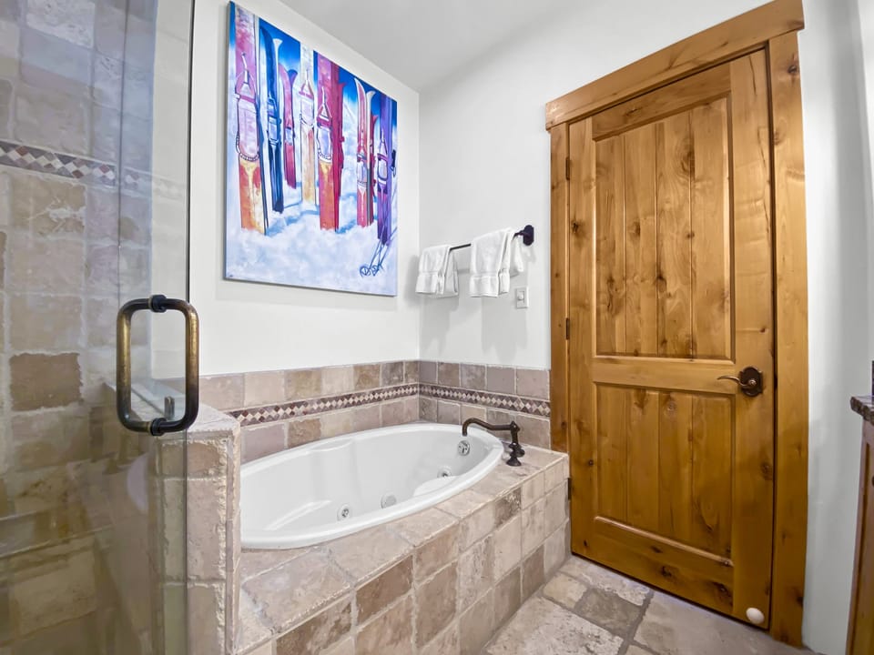 Sink into your private jetted tub and let the day melt away. Warm stone tile and a cheerful splash of wall art make this your perfect retreat for relaxation.