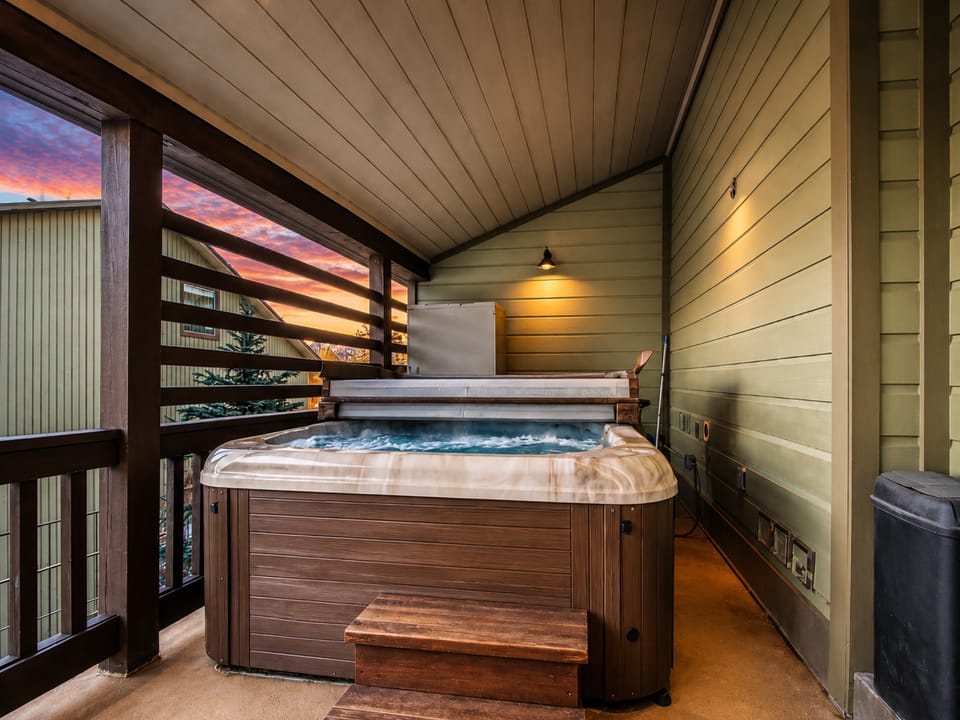 Sink into the bubbling warmth of your private hot tub as the sky glows with a stunning sunset just beyond your covered balcony.