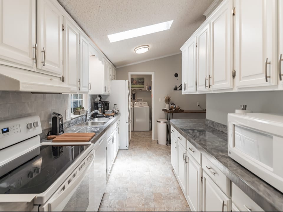 Spacious kitchen- many extras-airfryer, instapot, crockpot, microwave, blender, mixer, coffee grinder, spices. Stocked with cookware and dinnerware. Coffee station