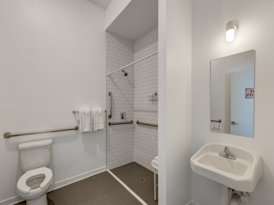 Note the step-free shower, grab bars, and open space below the sink