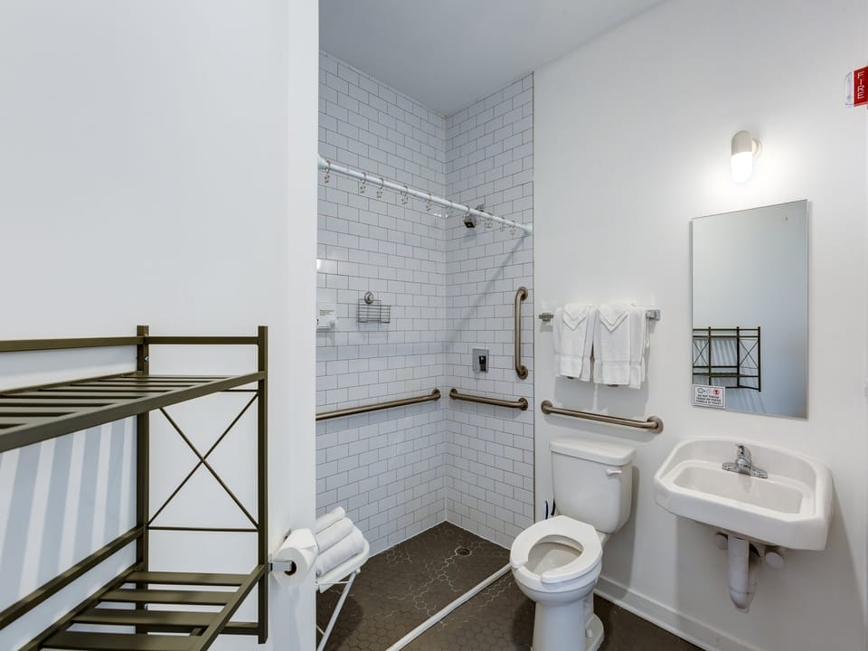 Note the step-free shower, grab bars, and open space below the sink