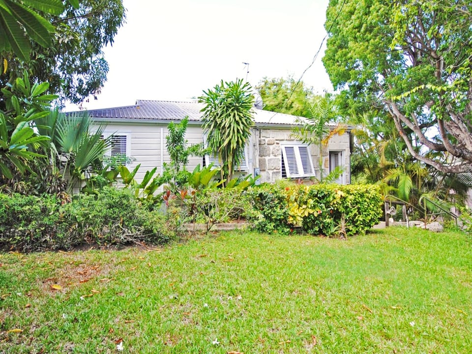 A side view of the cottage. Parking is available to the left, and this lawn is a great area for kids to play