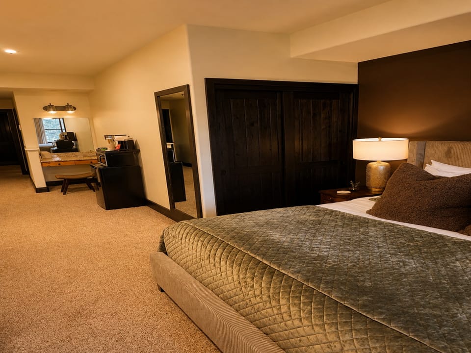 Sink into the plush bed after a day of adventure, with a thoughtfully designed space that blends modern comfort and warm tones to make you feel right at home.