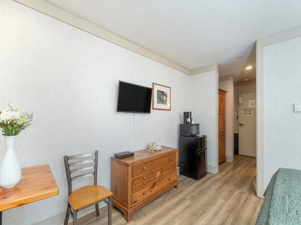 Unwind in your cozy space with warm wood furnishings, flat-screen TV, and mini-fridge for convenient snacks and drinks.
