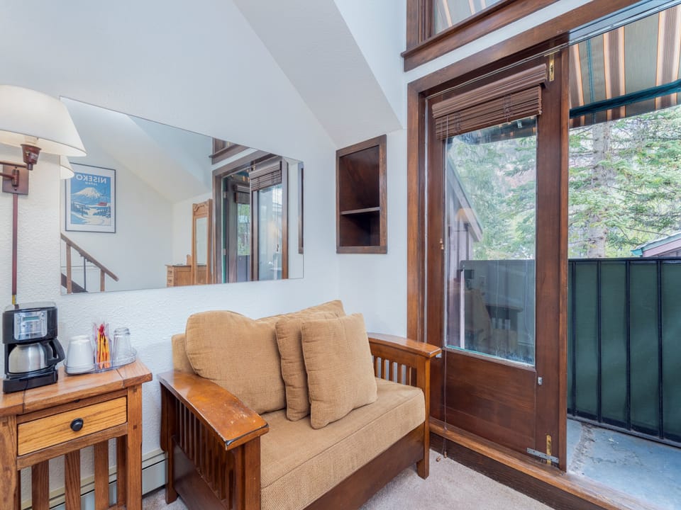 Settle into this cozy reading nook with mountain views, vaulted ceilings, and a warm loveseat perfect for morning coffee or evening relaxation.