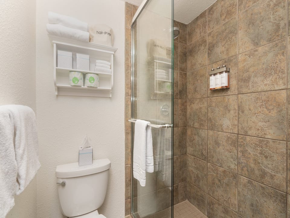 Step into your spa-like bathroom featuring a spacious walk-in shower with rainfall showerhead and plush towels awaiting your arrival.