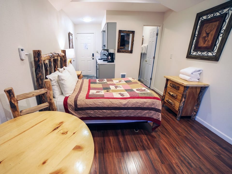 Queen Bed and Kitchenette in Background
