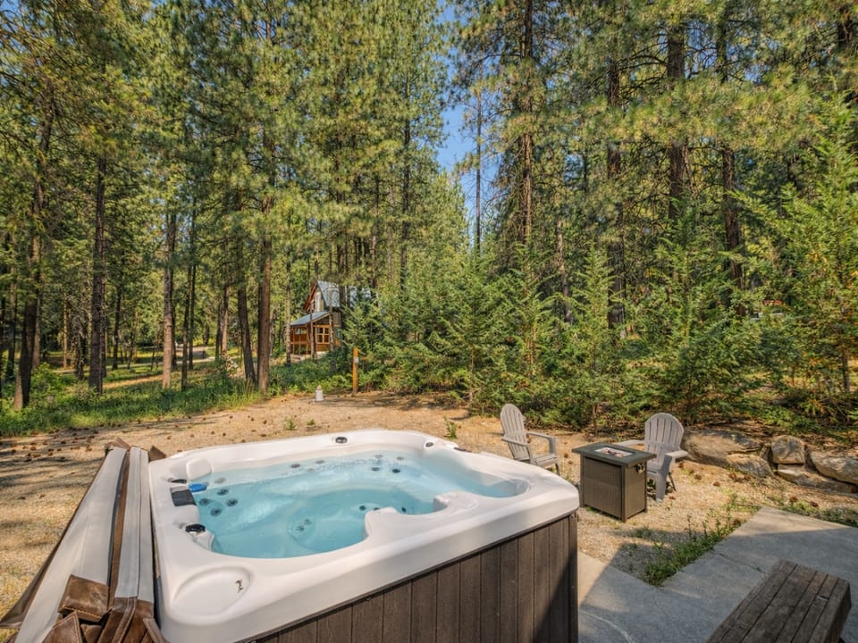 Soak in the private hot tub surrounded by towering pines, where forest serenity meets ultimate relaxation.