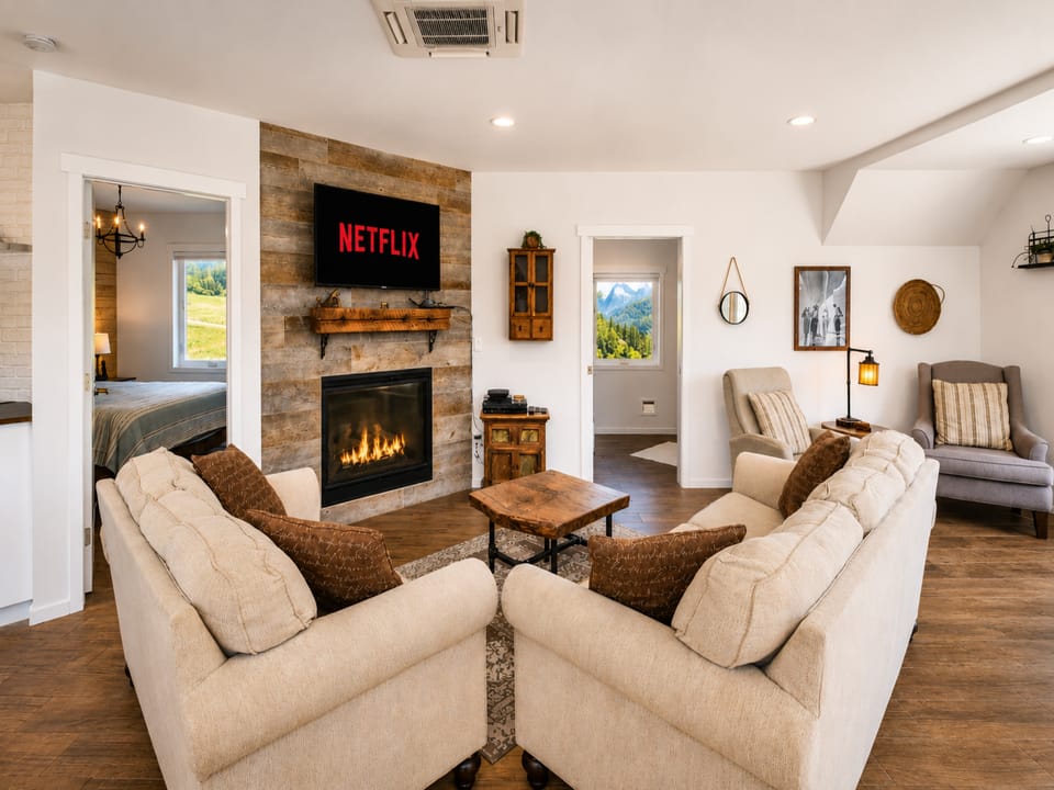 Sink into plush seating by your glowing fireplace while streaming your favorite shows. This inviting space flows effortlessly from cozy living to peaceful mountain-view bedroom.