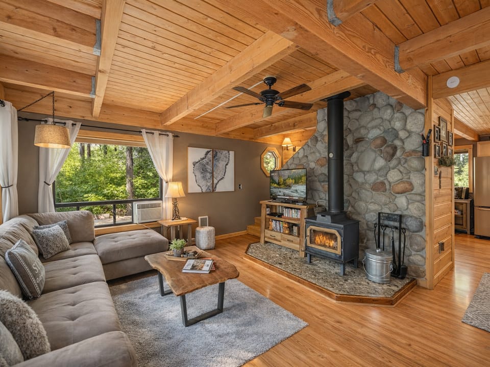 Cozy up in this rustic living room where warm wood beams frame your mountain retreat and a crackling fireplace awaits your evenings.