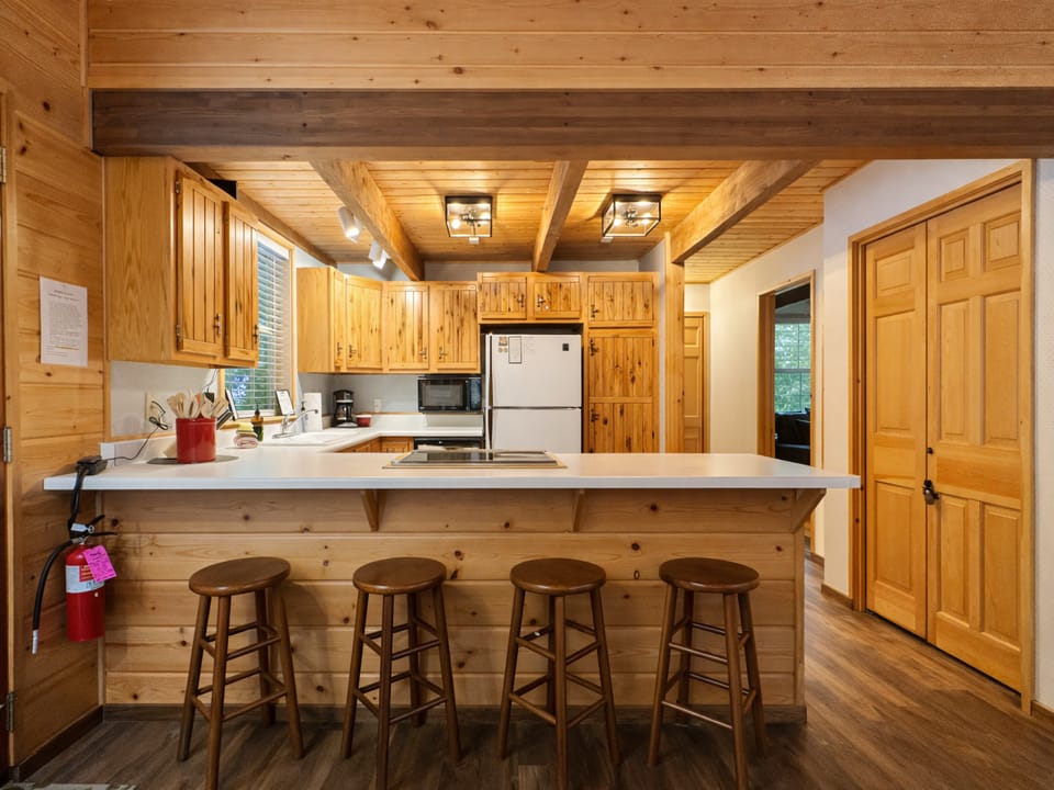 Your rustic kitchen welcomes with warm wood and a spacious breakfast bar for casual meals and coffee conversations.
