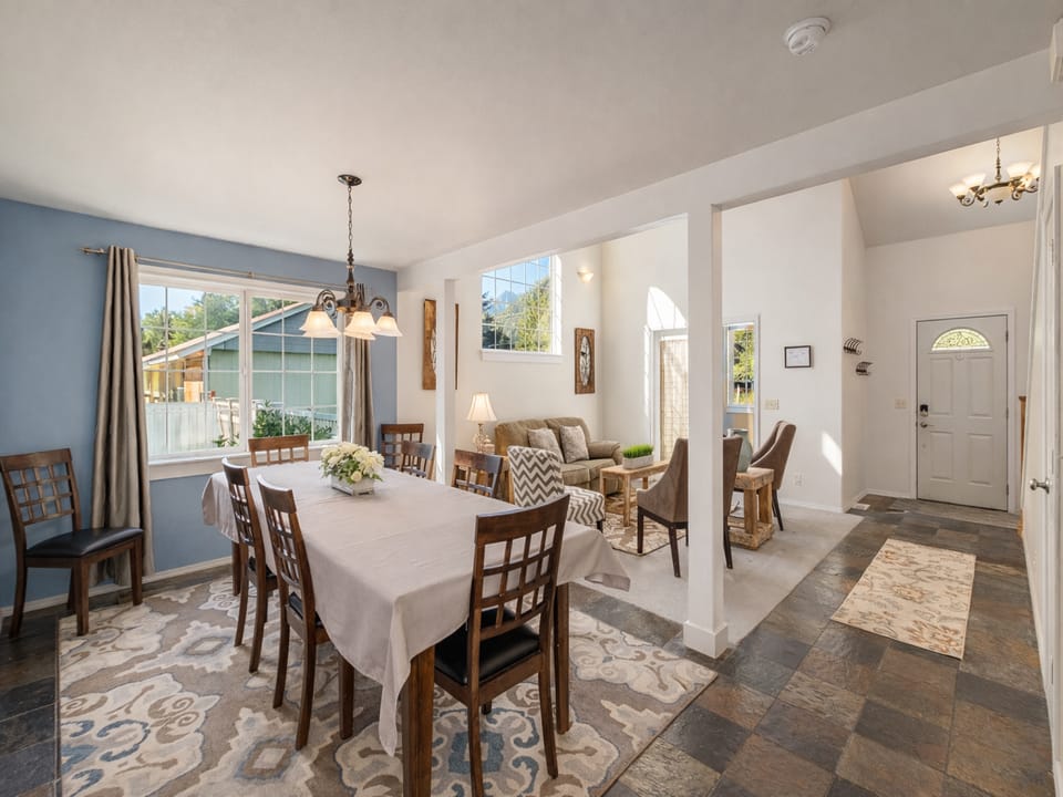 Gather around this welcoming dining table where natural light streams through large windows, creating the perfect spot for your morning coffee or evening meals.