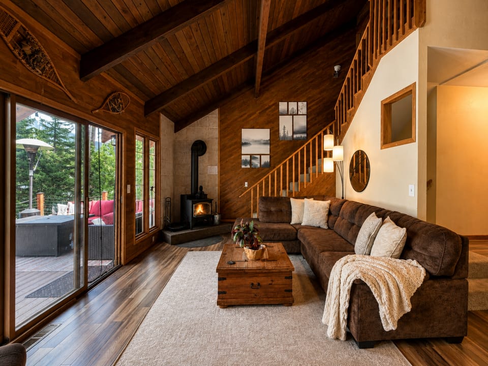 Living area with cozy couch, Fish Lake views, woodstove and streaming TV.