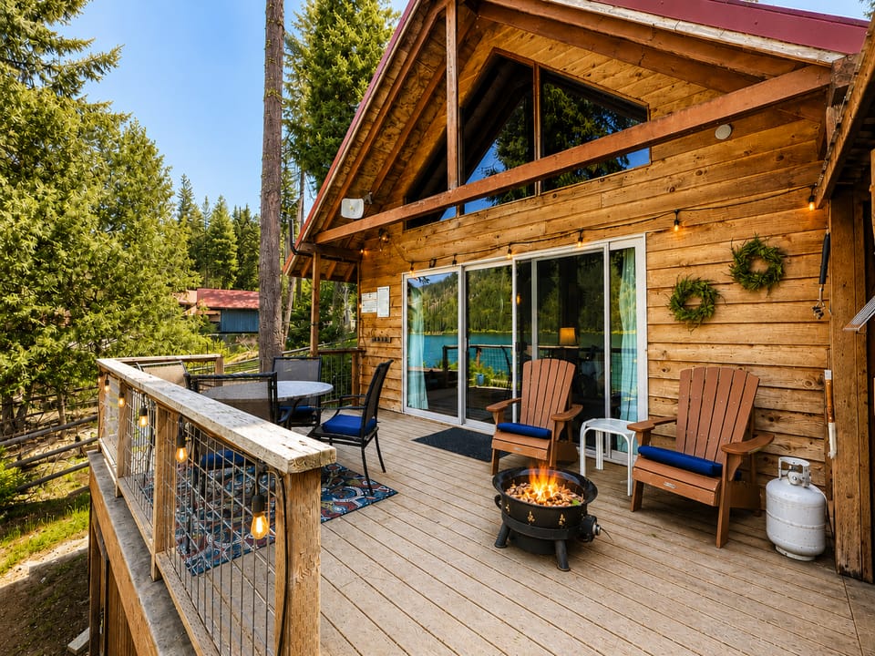 Unwind on your private deck with cozy seating around the fire bowl, surrounded by towering pines and lake views, perfect for evening relaxation.