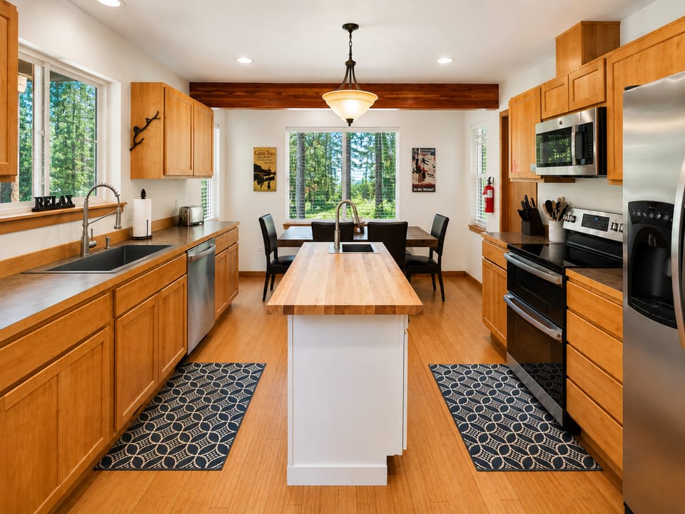 Full kitchen with prep island and large dining table for gathering.