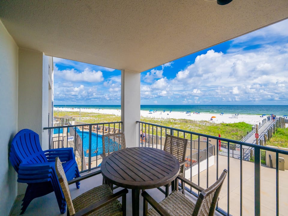 Gentle gulf waves hum nearby as you relax around the round table on your shaded balcony