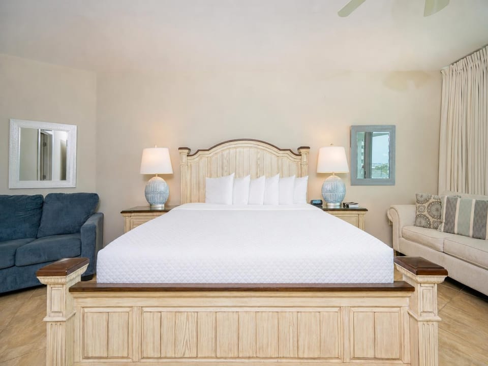 Bright and inviting master bedroom featuring a plush king bed, cozy seating area, and stylish lamps for a relaxing getaway