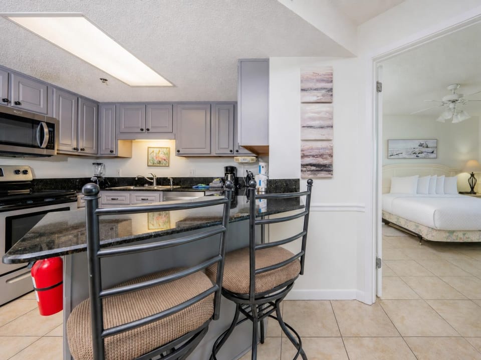 Modern kitchen with granite countertops, a breakfast bar with seating, and stainless appliances