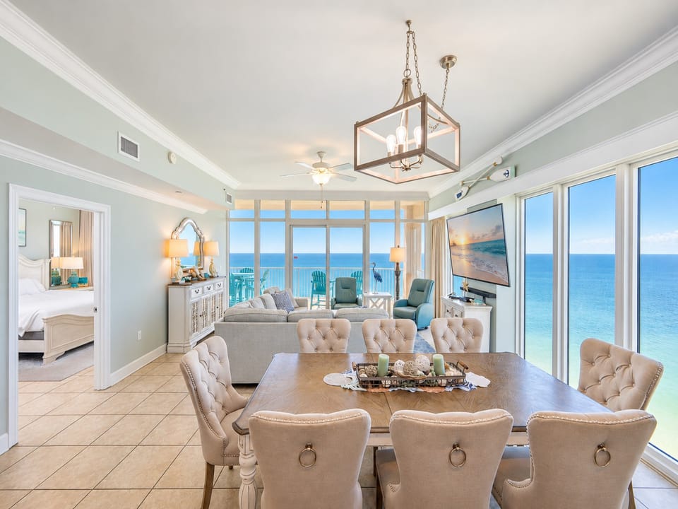 Unwind in the spacious living area, featuring a cozy sofa, elegant dining table, and expansive windows with beach views