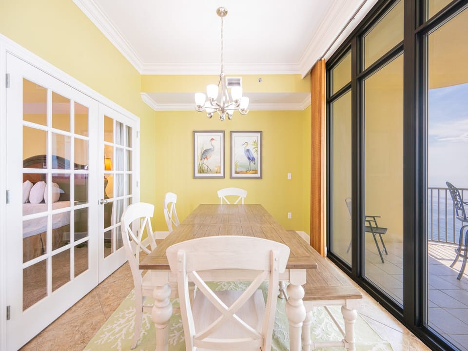 Sunlight warms the dining room as you gather around the sturdy table with coastal views beyond sliding glass doors