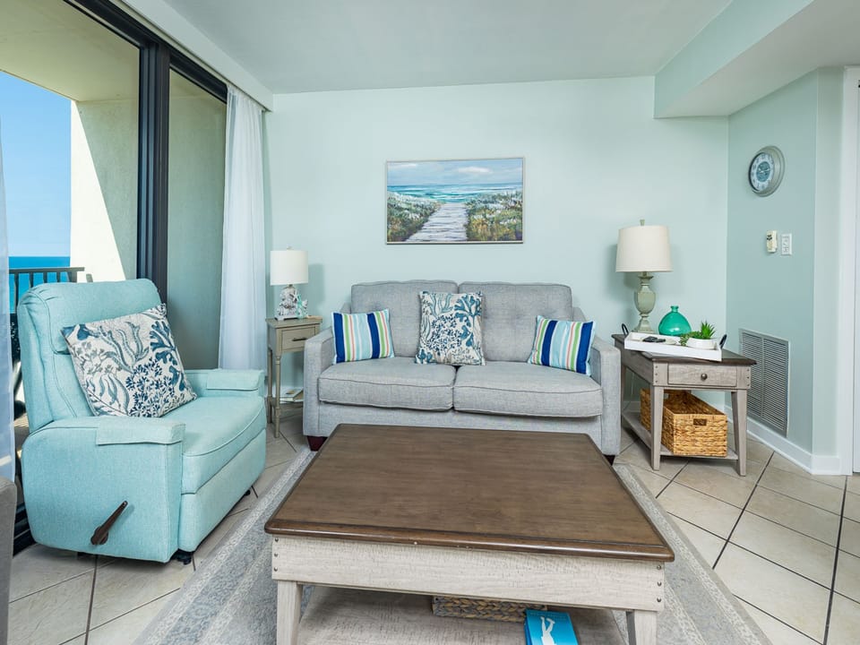 Cozy living room with a couch and two chairs, all with stunning Gulf views