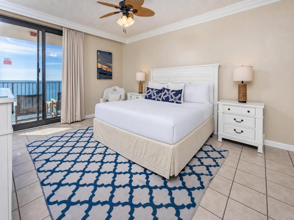 Unwind in this inviting master suite featuring a plush king bed, coastal decor, and direct access to beautiful beach views