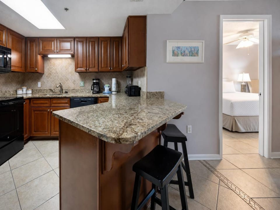 Warm wooden cabinetry complements the granite countertops in this inviting kitchen area, featuring a convenient breakfast bar