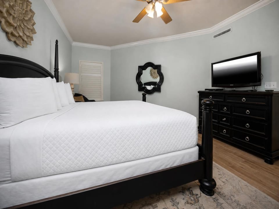 Unwind in this serene master bedroom featuring a king bed, stylish decor, and a flat-screen TV for your entertainment