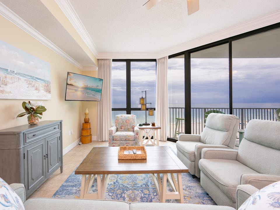 Relax in this inviting living area featuring a sofa with queen sleeper and large window showcasing tranquil water views