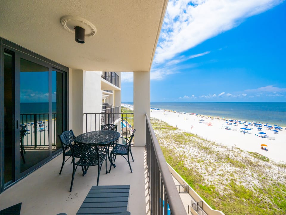 A stylish outdoor dining set overlooks the beach front, offering a perfect spot to enjoy the scenic coastal view