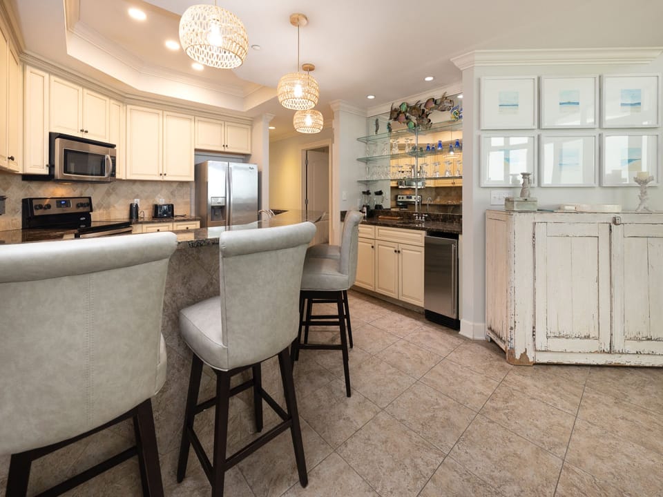 The kitchen features granite countertops, stainless appliances, and a stylish wet bar, perfect for entertaining