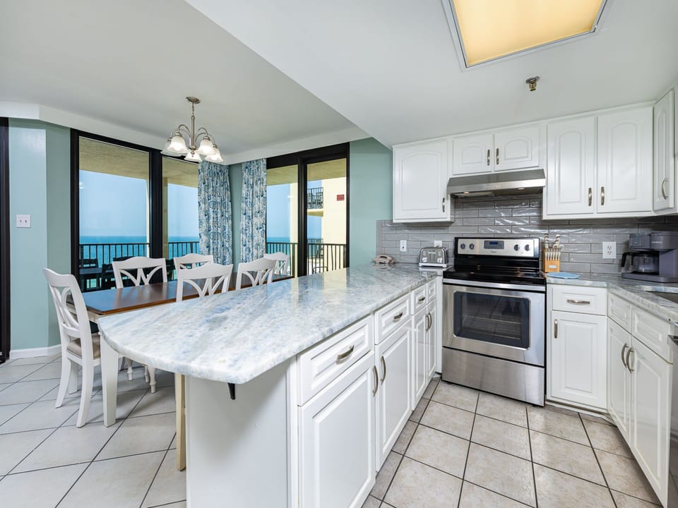 Kitchen featuring white cabinetry, a spacious countertop, stainless appliances, Keurig and a coffee maker