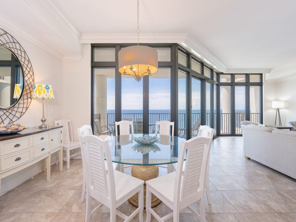 Bright dining area and a stunning coastal view through floor-to-ceiling windows