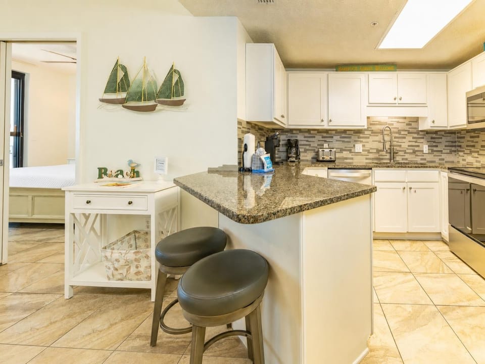 Smooth granite breakfast bar invites casual mornings filled with coffee aromas and quiet moments in the kitchen