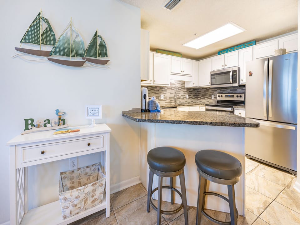 Gather at the sleek bar stools for a casual meal or drink while enjoying the inviting kitchen atmosphere