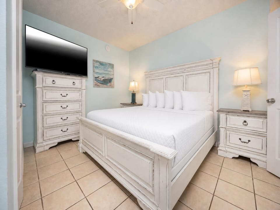 Unwind in the serene bedroom featuring a plush king bed, stylish furniture, and calming blue accents for a restful stay