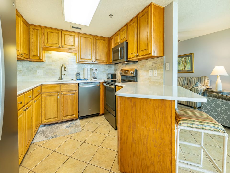 Warm wooden cabinets adorn the kitchen, featuring a coffee maker, sleek style, and ample storage