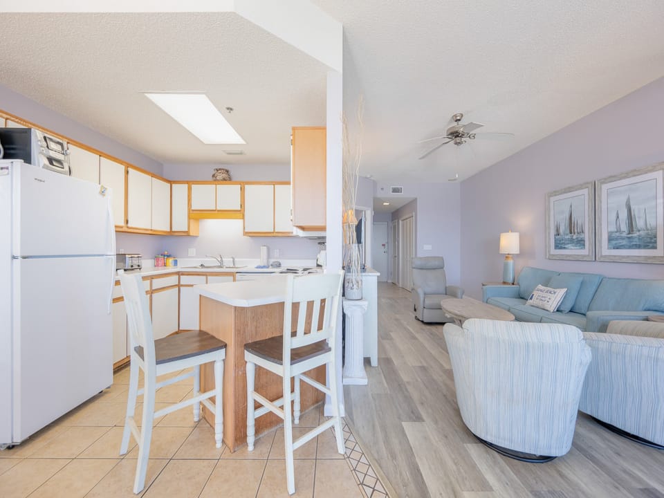 Bright kitchen area featuring white cabinetry, a breakfast bar with seating, and a view towards the dining space