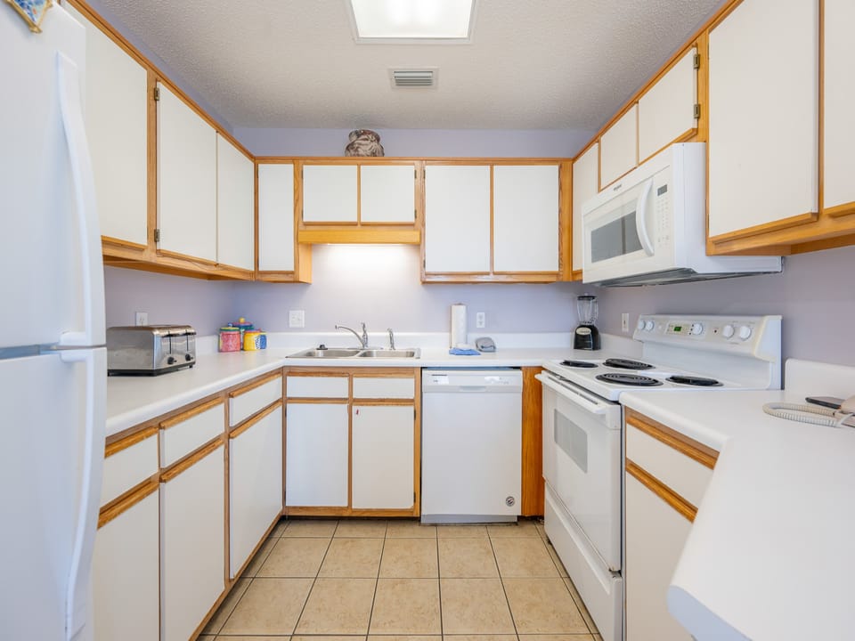 Kitchen features white cabinetry, a double sink, and a convenient layout, perfect for preparing meals during your stay