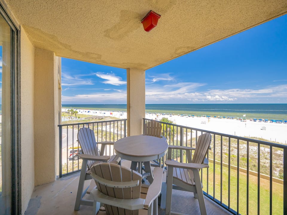 Relax on the balcony with a round table and chairs, enjoying the serene beach view and gentle gulf breeze