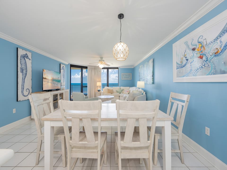 Coastal living area features a light-filled space with a comfortable sofa, dining table, and views of the beach