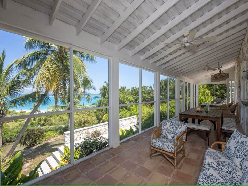 Screened porch with areas for lounging and dining.