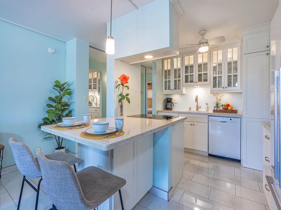 Whip up your morning coffee in this bright kitchen with gleaming countertops, modern appliances, and a charming breakfast bar perfect for relaxing over brunch.