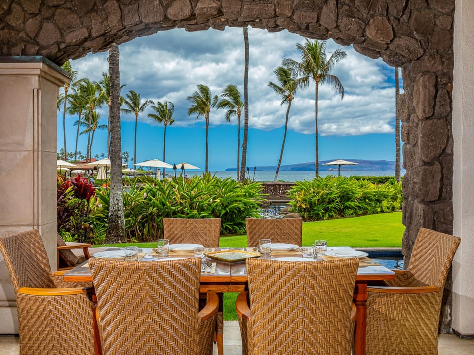 Dine al fresco overlooking lush tropical gardens, swaying palms, and vibrant blue ocean waters. A serene oceanfront setting perfect for unforgettable coastal moments.