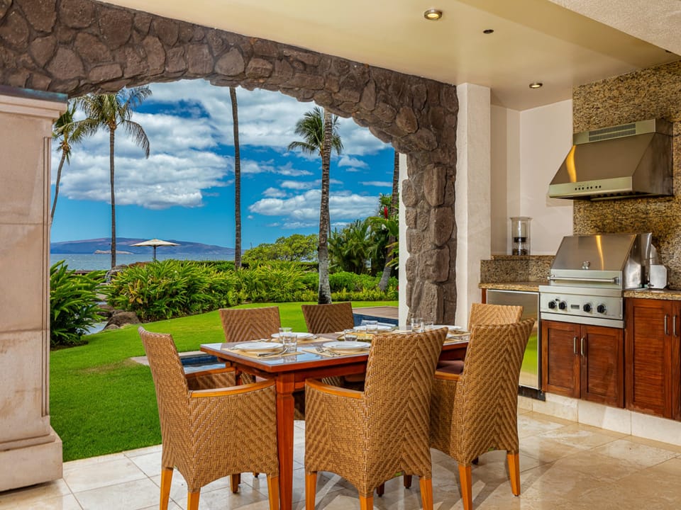 Dine al fresco under your covered patio with stunning ocean and island views stretching to the horizon, tropical palms swaying nearby.
