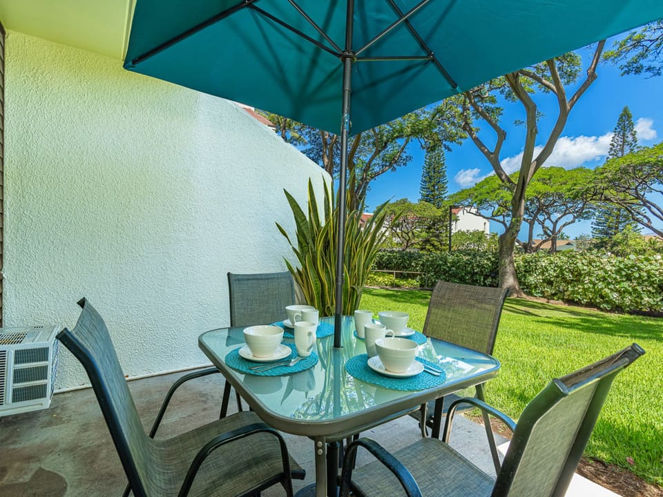 Picture yourself enjoying your morning coffee at this private patio, where lush green lawns and shaded tropical trees create your peaceful island retreat.