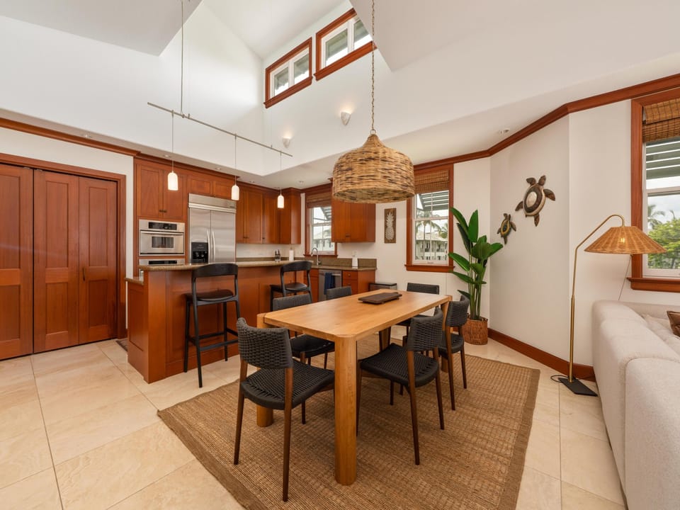 Gather around the inviting dining table, where warm wood tones and island-inspired décor create the perfect space for memorable meals and laughter together.