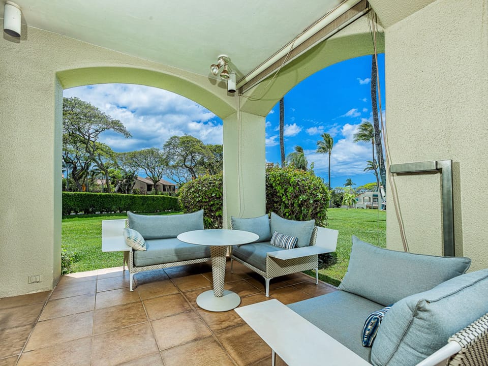 Unwind on your private lanai with refreshing ocean breezes, where plush seating and tropical vistas create your perfect island escape. This is your serene sanctuary for morning coffee or sunset relaxation.